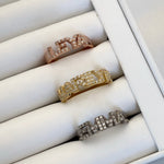 A set of silver rings with varying designs, displayed in a box, with one ring featuring a custom stone word inscription.