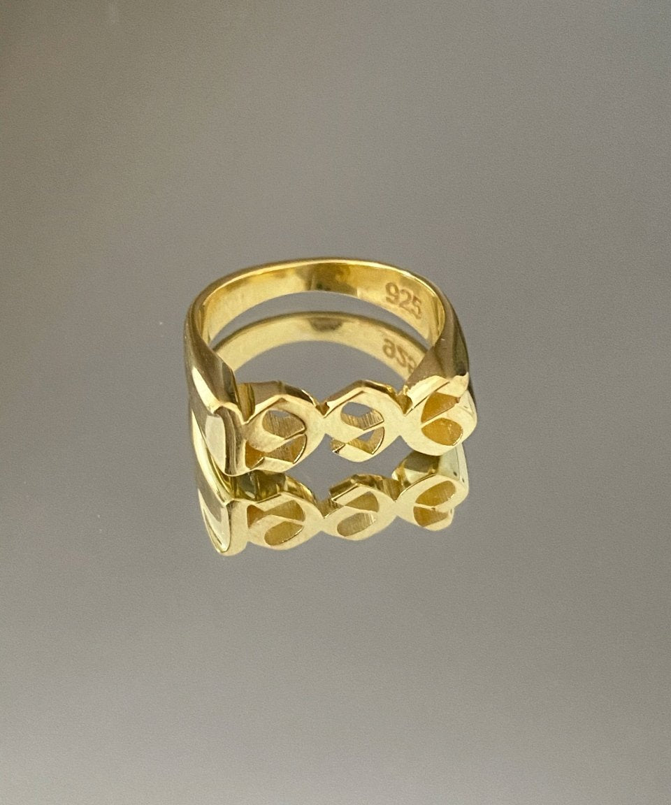 A gold-colored metal ring with a geometric pattern, featuring the inscription '925' on the inside.